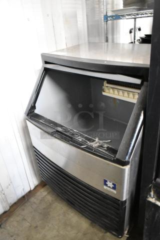 Manitowoc QY0134A stainless steel commercial ice machine, self-contained, visible wear, model tag present.