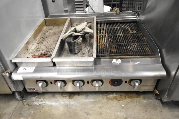 APW Wyott stainless steel commercial gas charbroiler grill, used condition, with visible knobs and cleaning brush.