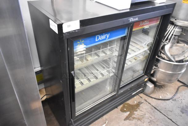2019 True GDM-41SL-48-HC-LD 2-door cooler with poly-coated racks, glass doors, 115V, slight wear, dairy and juice signage.