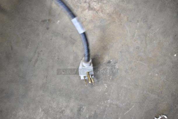 Power cord for the 2019 True GDM-41SL-48-HC-LD 2 Door Reach In Cooler, showing plug on concrete floor.