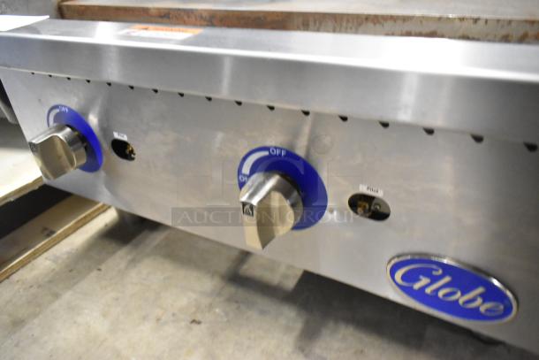 Globe GG24G stainless steel commercial gas griddle, 60,000 BTU, with control knobs and pilot light indicator.