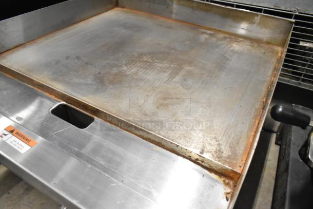 Globe GG24G Stainless Steel Gas Griddle, 60,000 BTU, commercial use, visible wear, warning label present.