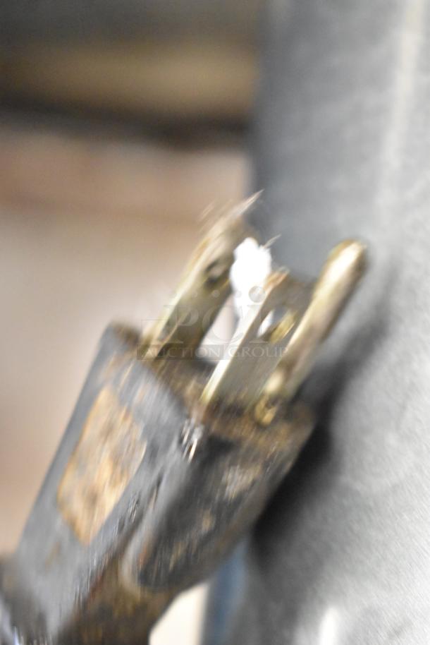 Blurry close-up of a metal plug from an Avantco MX30 dough mixer, unclear condition.