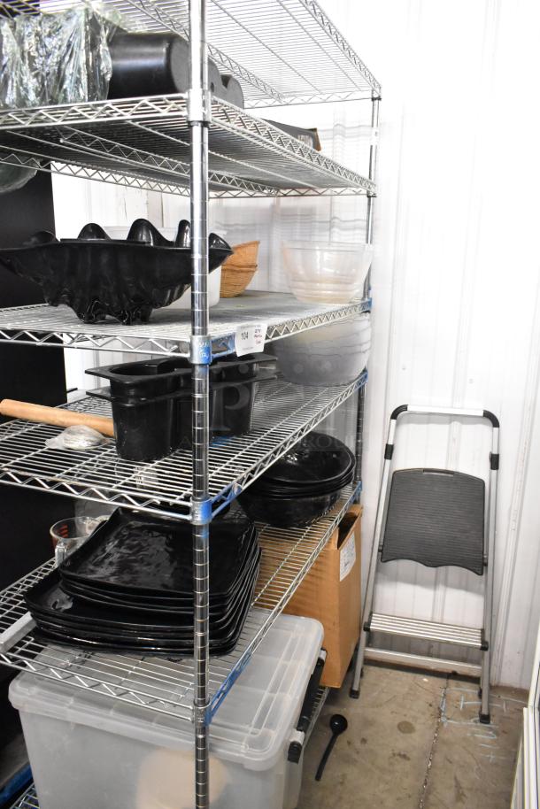 Metro lot with various items: black plates, bowls, poly bin. Shelving unit not included. Items in good condition.