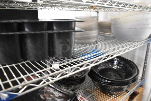 Metro lot featuring assorted plates, bowls, and a poly bin on a wire shelf. Items appear in various conditions. Shelving not included.