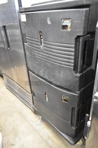 Cambro black poly 2 compartment heated holding cabinet, scuffed surface, visible handles, on casters, model markings faint.