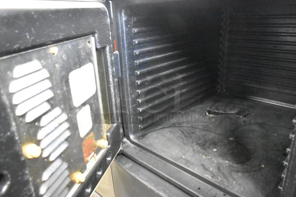 Cambro black poly 2 compartment heated holding cabinet interior, showing wear and labels. Ideal for maintaining food temperature.