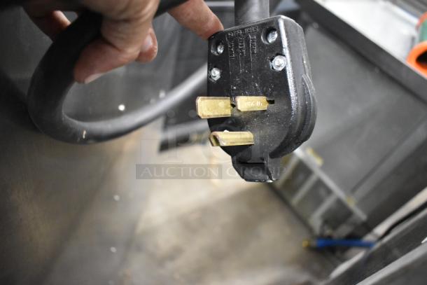 Close-up of the electric plug for Wittco 1200-2E1ZN stainless steel commercial heated holding cabinet, showing 208-240 volts, 1 phase compatibility.