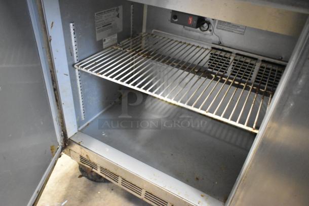Beverage Air SPE60-16C stainless steel prep table with shelves, showing moderate wear. Suitable for commercial kitchens.