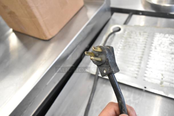 Power cord of Beverage Air UCR72AY-23 cooler, 115 volts, shown against a stainless steel surface.