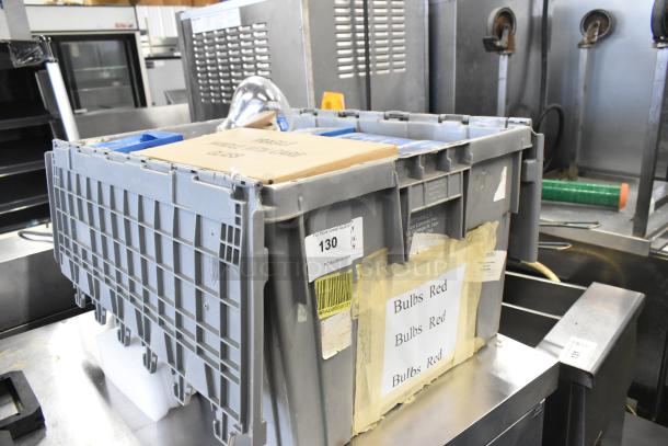 Gray poly bin containing new items, including a Bulbrite infrared heat lamp bulb. Labels read "Bulbs Red." Auction tag visible.