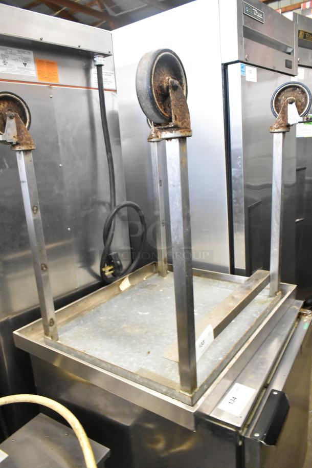 Stainless steel equipment stand with commercial casters, rust visible, designed for durability and mobility in industrial settings.