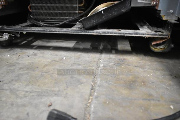 2016 True T-19F stainless steel commercial single door reach-in freezer underside, showing casters and compressor.