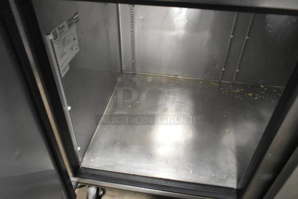 2017 True TPP-67 stainless steel commercial pizza prep table interior with residual crumbs; on commercial casters.