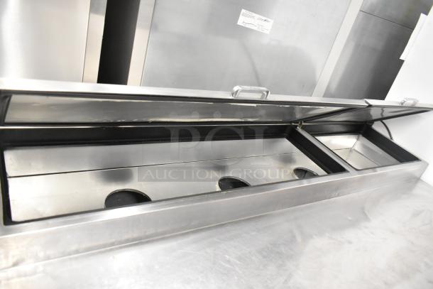 2017 True TPP-67 stainless steel commercial pizza prep table, 115V, 1 phase, with commercial casters, open lid view.