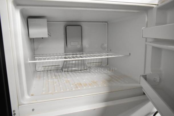 Maytag single door reach-in cooler with freezer, 115 volts, 1 phase. Clean interior, visible shelving, shows minor wear.