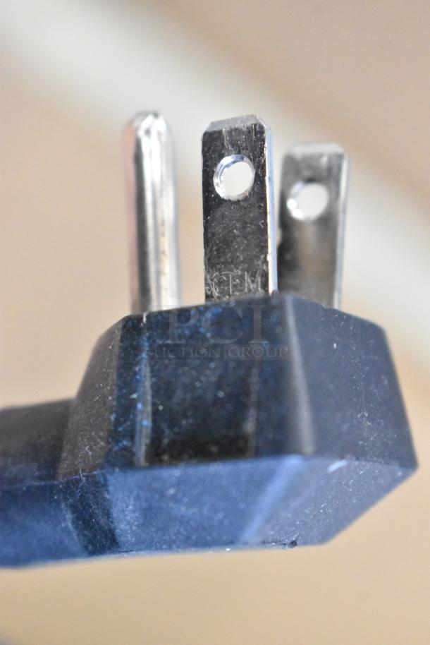 Close-up of a metal plug for Imbera EVC04 Mini Cooler Merchandiser, 115 volts, 1 phase, showing prongs and details.