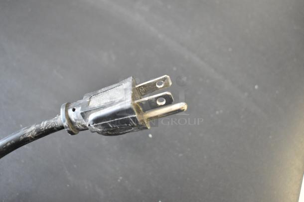 Close-up of a black electrical plug for the 2021 IDW G4-H0234B Metal Mini Cooler Merchandiser. 110-120 Volts, 1 Phase.