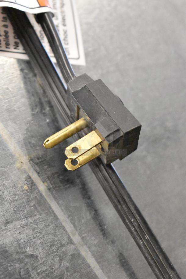 Close-up of a Maytag M1TXEGMYW01 cooler power plug, showing a 115-volt, single-phase configuration.