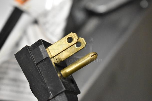 Close-up of a Whirlpool cooler's power plug. Three-prong gold connector, suitable for 115 volts, 1 phase power supply.