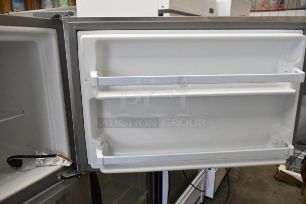 Whirlpool stainless steel reach-in cooler with freezer, single door, 115 volts, 1 phase. Door open showing interior shelves.
