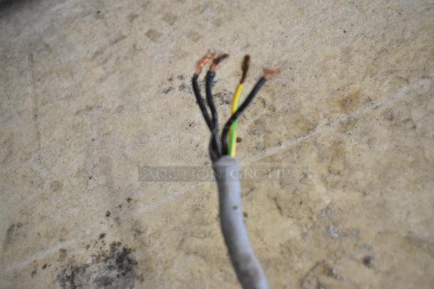 A frayed electrical wire with exposed copper threads on a neutral background.