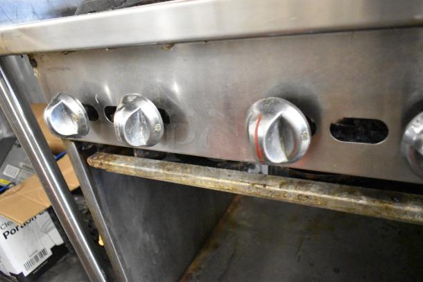 Jade Range JSR-6 stainless steel commercial gas range with 6 burners and undershelf. Visible wear on knobs and shelf.