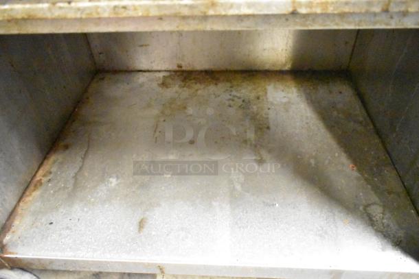 Jade Range JSR-6 stainless steel commercial gas range, featuring a 6-burner setup with an under shelf, showing signs of use.