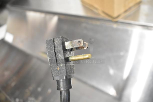 Close-up of an electrical plug, indicating a component from the Migali CA412 Stainless Steel Salad Prep Table.