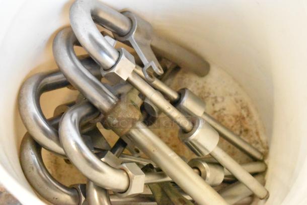 US Bottlers Machy Co metal siphon filler components in a bucket, showcasing stainless steel parts and industrial design.