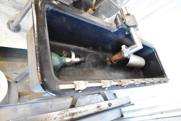 US Bottlers Machy Co metal floor-style siphon filler with visible nozzle. Condition shows wear consistent with industrial use.