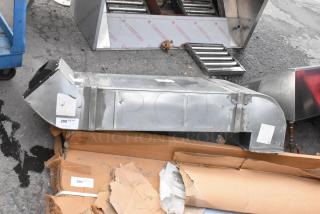 Metal duct in used condition, featuring rectangular shape and visible labels. Ideal for HVAC systems.