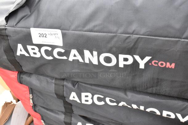 4 ABC Canopy Pop-Up Canopies in black bags, features brand logo, includes auction lot tag indicating quantity of four.
