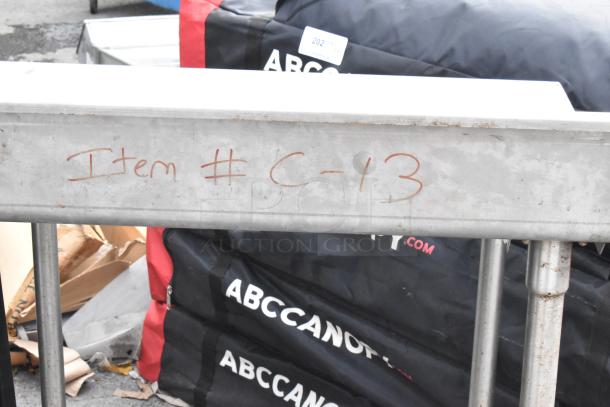 Stainless Steel Table with Back Splash, labeled "Item #C-13", sturdy legs, minor wear, durable industrial design.