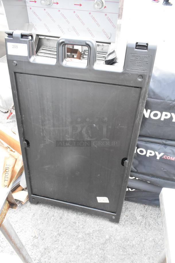 Black Poly A-Frame Sidewalk Sign, durable plastic, lightly used condition, "Signicade Deluxe" label, fill with sand option.