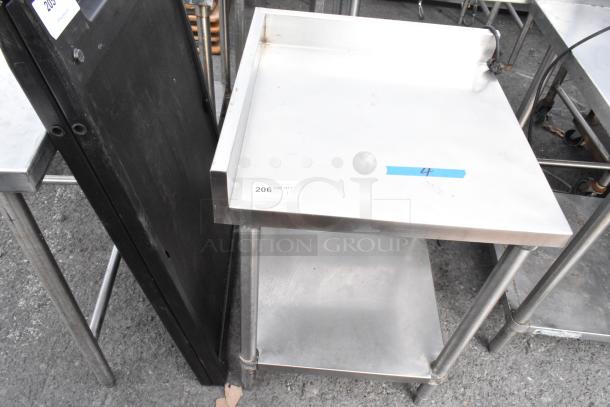 Stainless steel table with under shelf, in good condition, features back splash and sturdy legs. Tag indicates item 206.