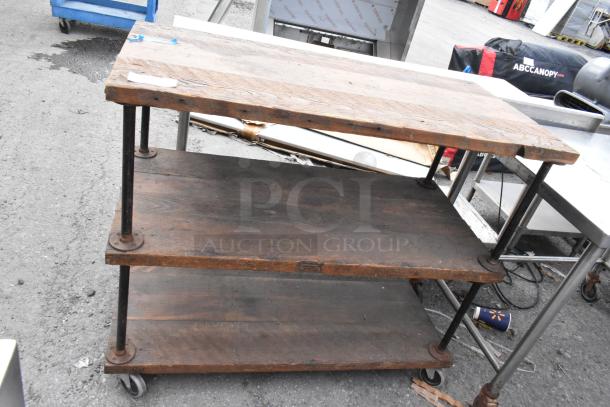 Wooden and metal 3 tier cart on commercial casters, featuring dark wood shelves and sturdy metal supports. Good condition.