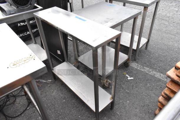 Stainless steel table with under shelf, used condition, on casters, minor surface wear, ideal for commercial use.