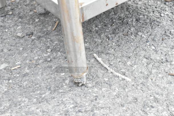 Stainless steel table leg with rust spots, showing wear.