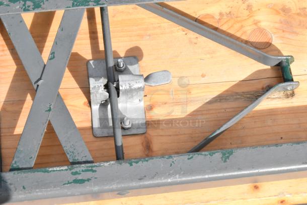 16 wooden folding tables with metal hinges and supports, showing wear. Ideal for events or gatherings.