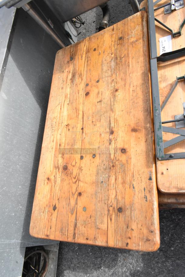 16 various wooden folding tables, showing rustic wear. Each bid multiplies by 16. Includes sturdy metal hinges and frames.