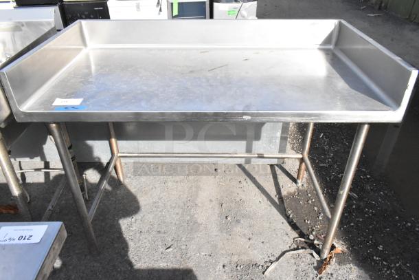 Stainless steel table with back splash, industrial design, sturdy legs, slight surface wear, auction tag visible.