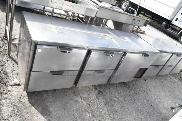 Stainless steel commercial undercounter cooler with 4 drawers, 1 door, on casters; 115V, 1 phase, visible wear.