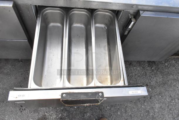 Stainless Steel Commercial Undercounter Cooler with 4 drawers, 1 door, on commercial casters. 115V, 1 Phase. "ICE" and "SELTER" labels on drawer.