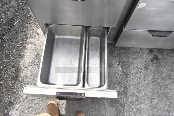 Stainless steel commercial undercounter cooler with 4 drawers, 1 door, on casters. 115 volts, 1 phase. Includes metal trays.