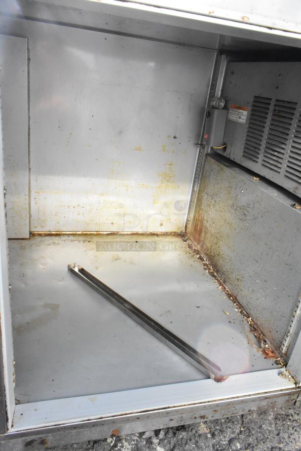 Stainless steel undercounter cooler with 4 drawers, 1 door, on commercial casters. 115V, 1 phase. Interior shows rust and wear.
