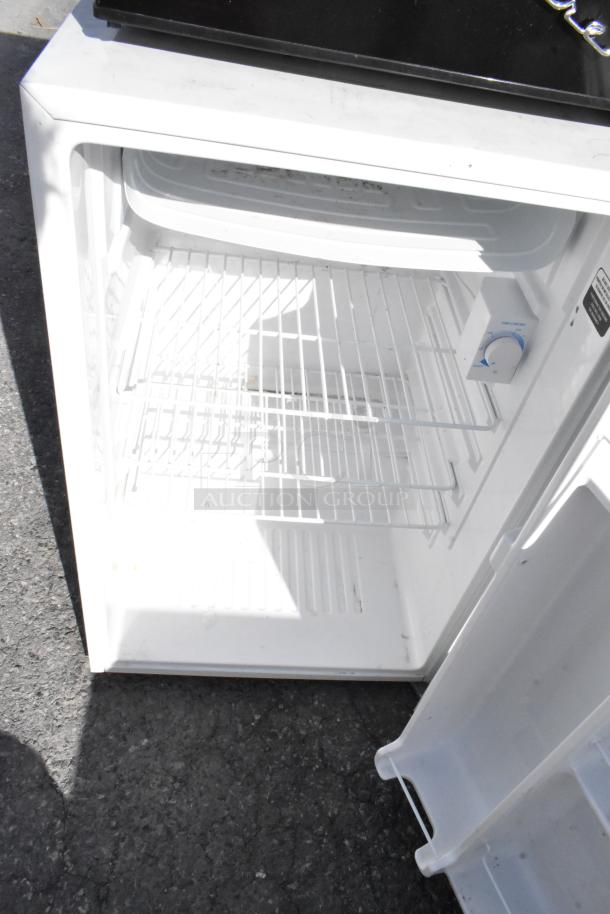 Interior view of a white mini cooler with wire shelving and a temperature control knob. 115 Volts, 1 Phase.