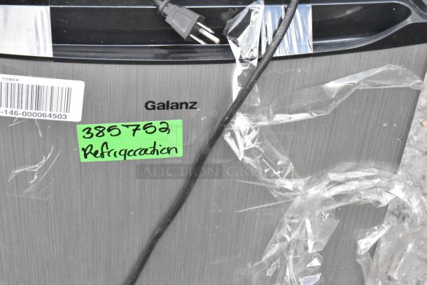 Galanz mini cooler, brushed metal finish, visible plug, plastic wrapping. Green label reads "385752 Refrigeration."