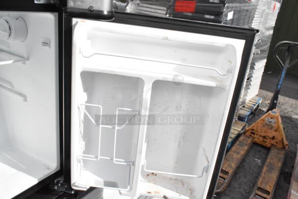 Inside view of a mini cooler door with wire racks and some marks. Item includes Galanz, GE, Whirlpool models. 115 Volts.