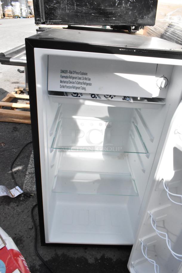 Open mini fridge with shelves, labeled with safety warning. Auction lot includes Galanz, GE, Whirlpool models, 115V, 1 phase.